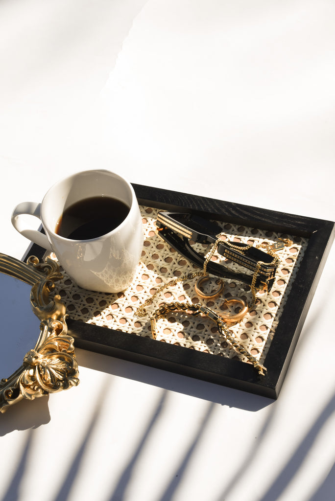 black organizer tray with cane design display personal accessories or cups of drink. 